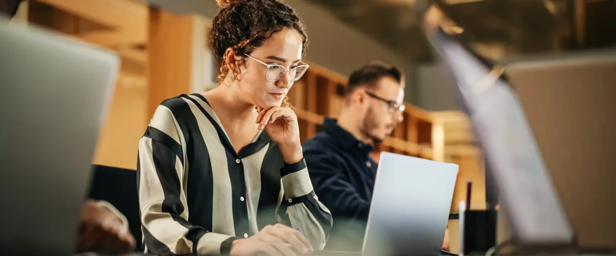 Portrait,Of,Enthusiastic,Hispanic,Young,Woman,Working,On,Computer,In